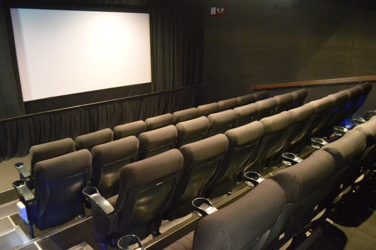 Rows of leather recliner seats facing a big screen